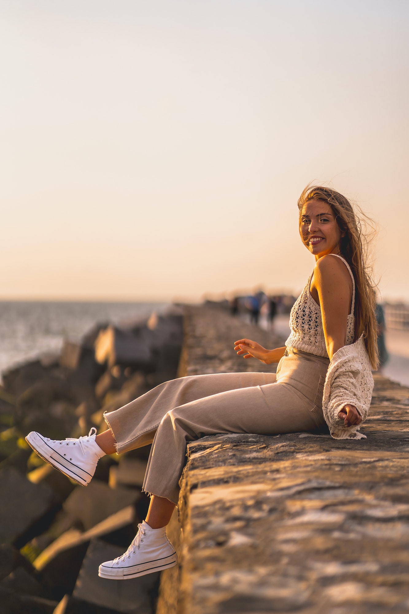 Summer lifestyle, a young blonde Caucasian woman sitting by the sea.